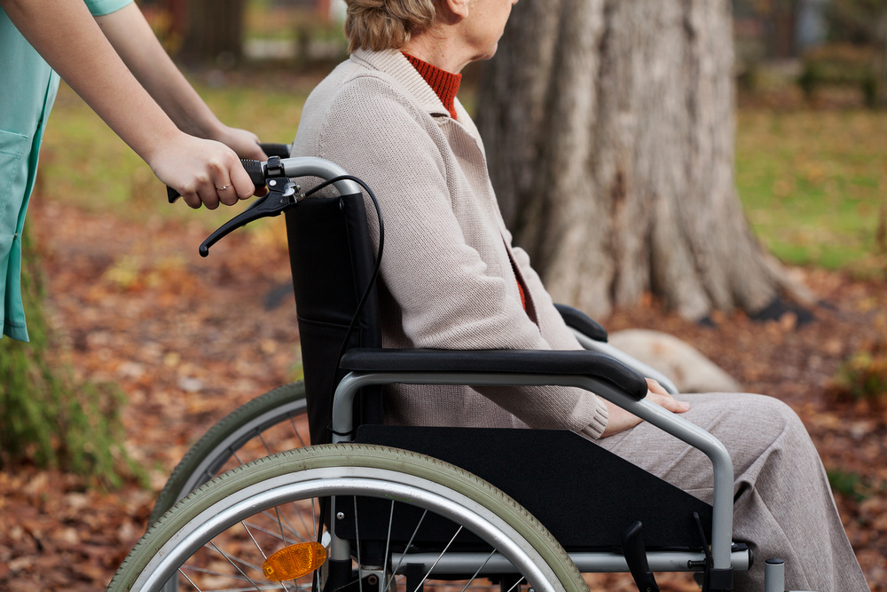 Disabled elder woman on wheelchair with nurse